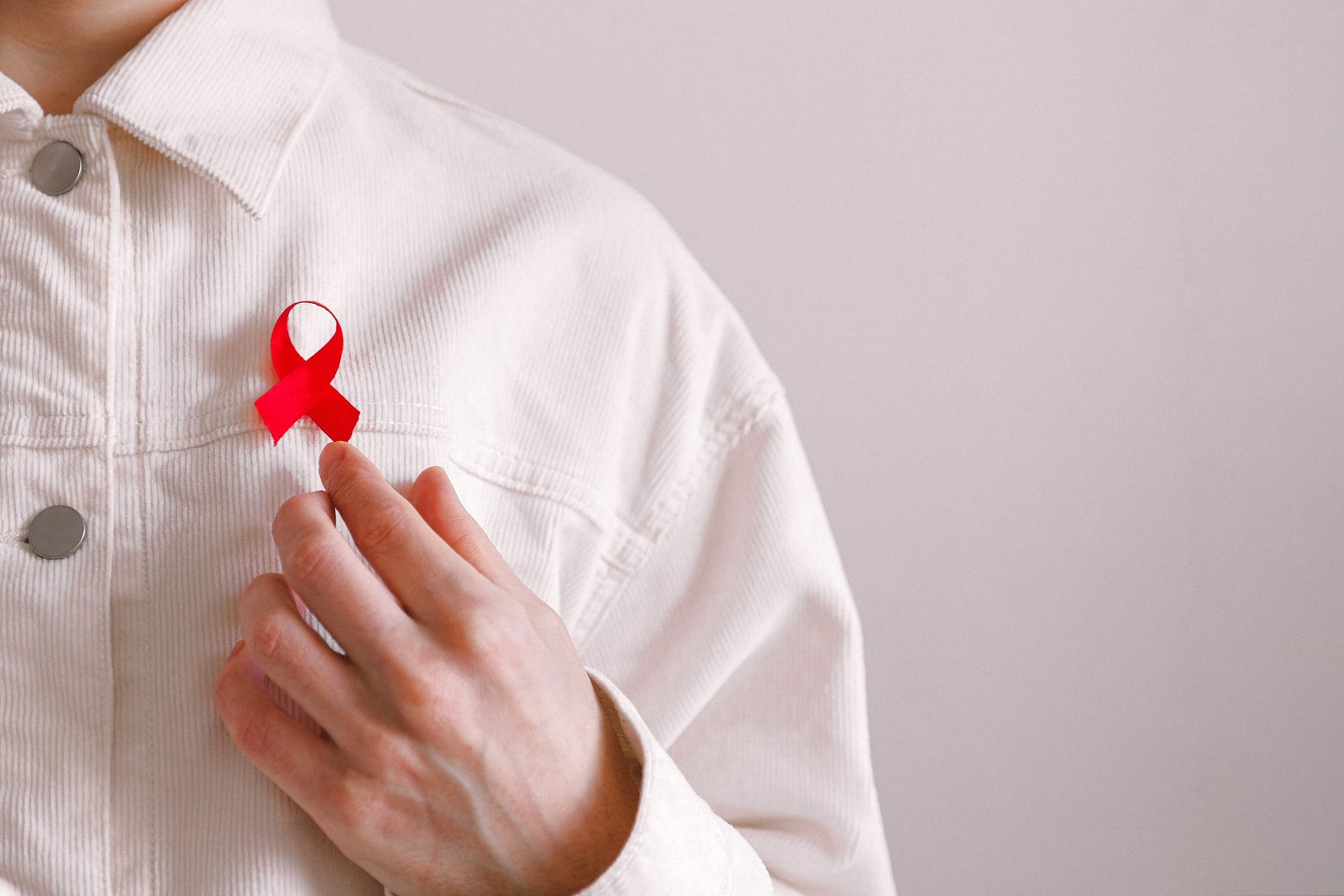 Mężczyzna z czerwoną wstążką na koszulce w Światowy Dzień AIDS